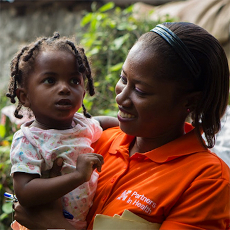woman in pih shirt holding a young girl