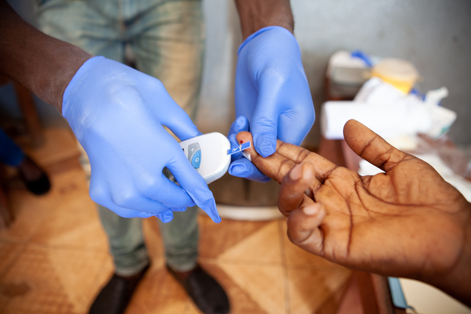 taking a blood sugar test for a patient in rural Liberia