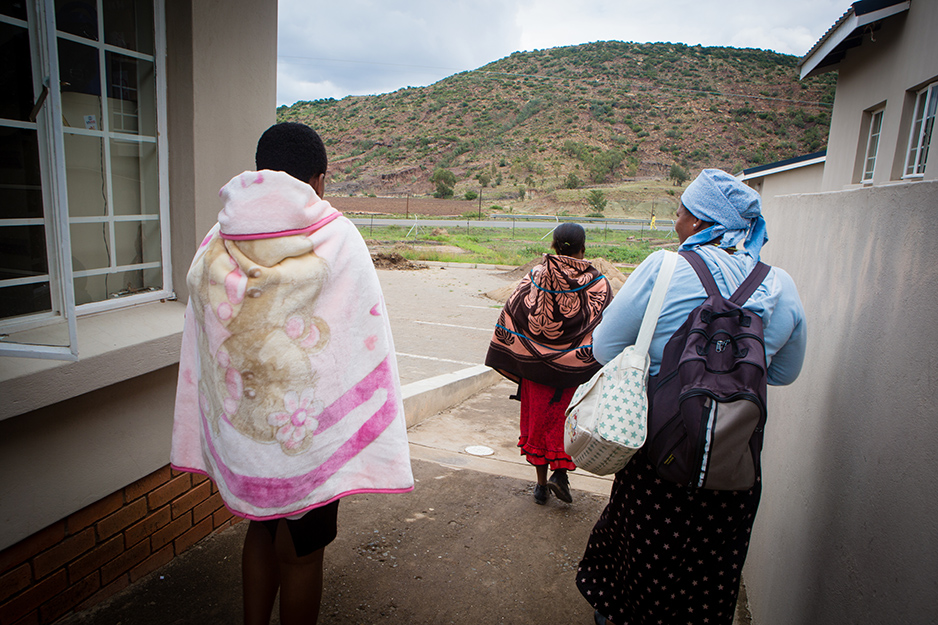 Matsebo (left) leaves the health center with her village health worker Malerato Tsoelesa (center), and her other son.