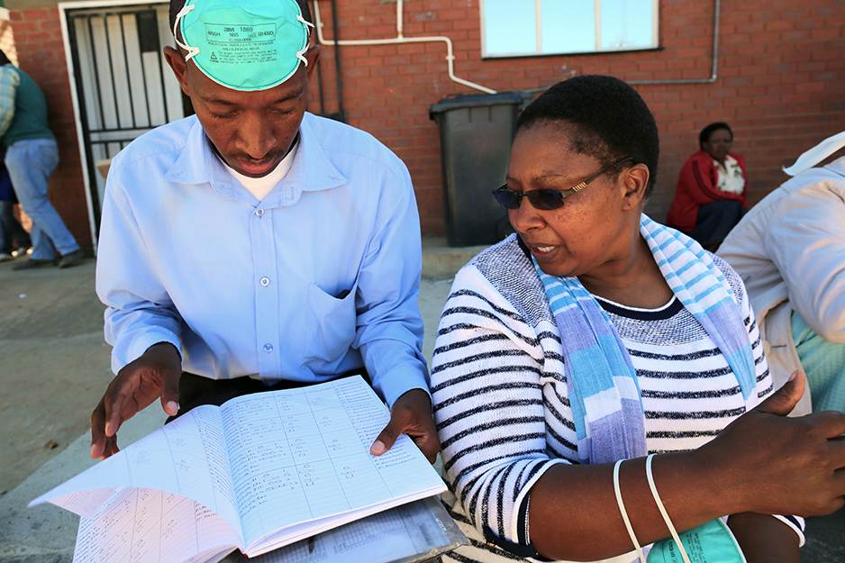 seko Motšela (left) and Nurse Likhapha Ntlamelle scan a patient’s medication log, which records the daily doses of drugs needed to treat MDR-TB, in Maseru, Lesotho, in March 2016.