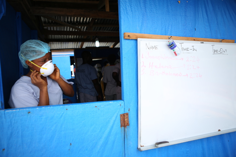 A clinician prepares before entering an Ebola treatment unit in Liberia
