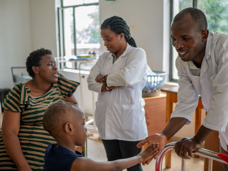 Olivier Habimanaand (right) and Esperance Benemariya, oncology nurse educators at PIH-supported Butaro District Hospital in Rwanda, meet with Keza Solange, who is being treated for leukemia, and her mother in the pediatric ward.