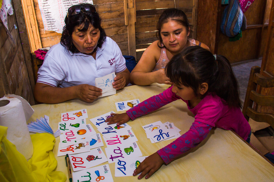 community health worker guides a family through interactive play in Peru