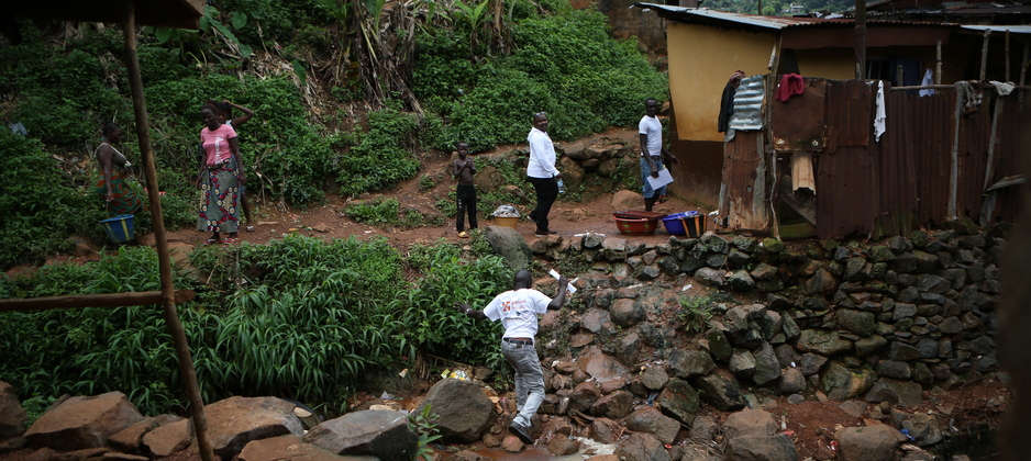 PIH staff visit the home of Ebola survivors in Sierra Leone, in 2014