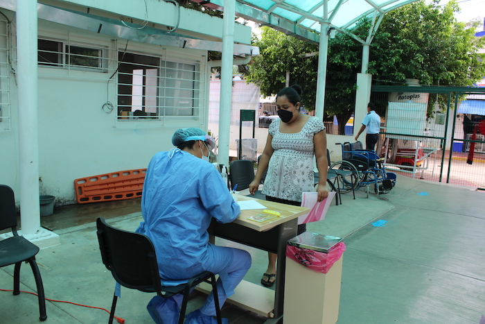 caregiver checking in patients for covid test