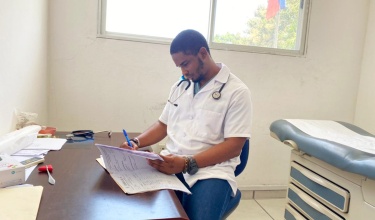 Family medicine doctor reviews patient file in Haiti