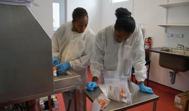 Lab technicians Myrlene Mompremier and Chantale Bellevue work in the pathology lab in the Mirebalais Reference Laboratory