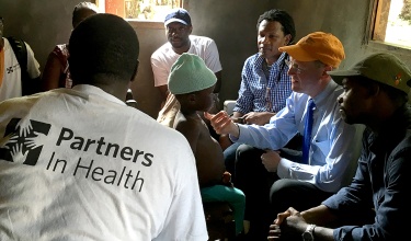 Dr. Paul Farmer examines an 8-year-old tuberculosis patient, during a home visit in Maryland County, Liberia.
