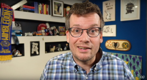 John Green looking into the camera in a room where he films vlogbrothers videos