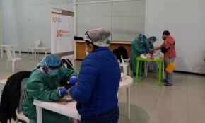 Socios En Salud staff conducting COVID-19 testing in a market setting
