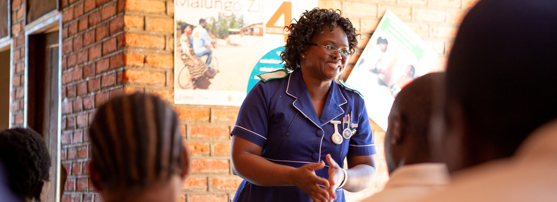 female nurse small at a small group of student sitting in front of her 