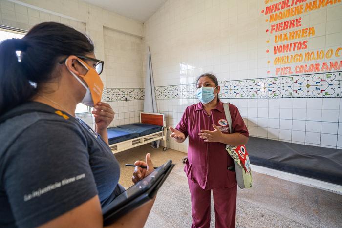 Two women discuss in a hospital room. 