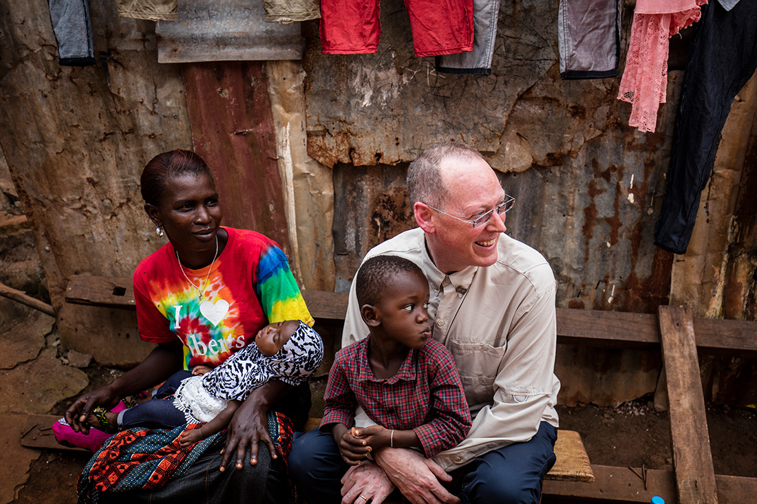 Dr. Paul Farmer sits with a child on his lap. 