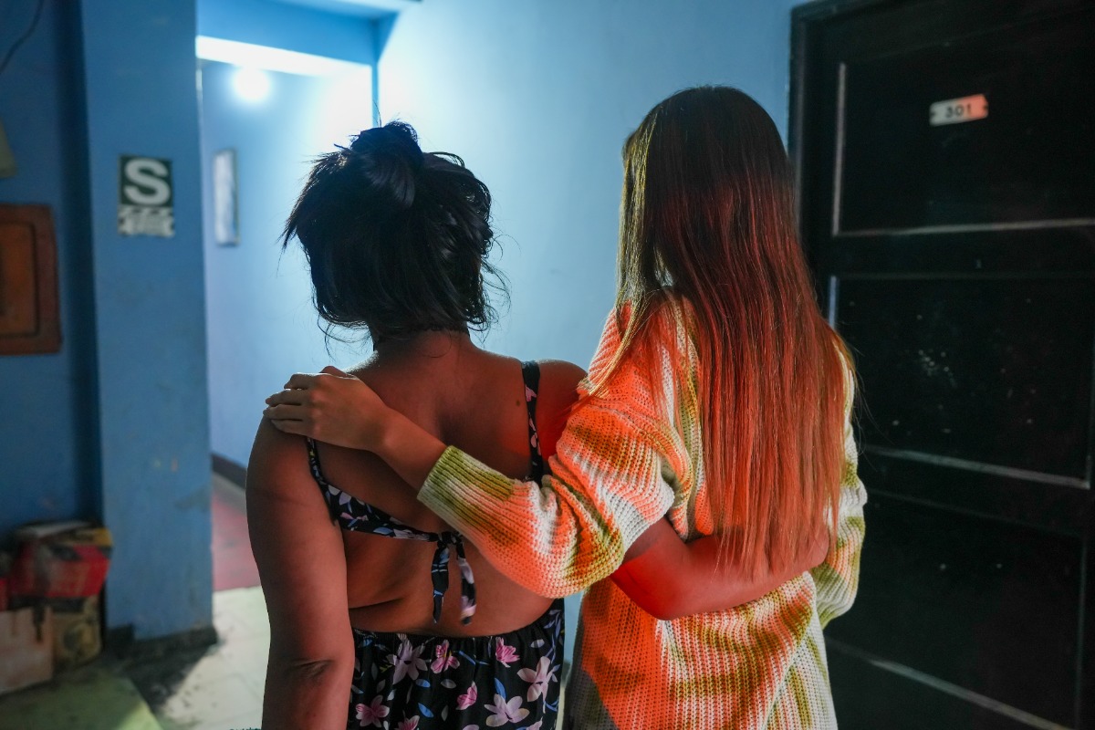 Alexia (name changed) stands with Carla Rodríguez, coordinator of JunTrans, Socios En Salud's project connecting transgender patients with care.
