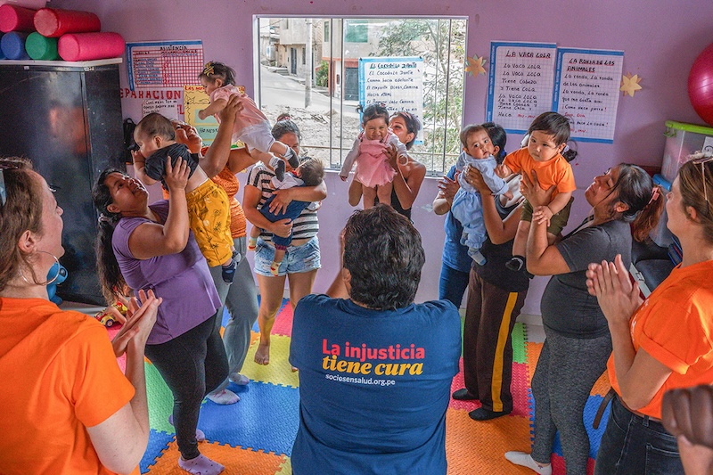 Caregivers and children meet in PIH office space in Peru.