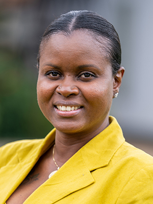 Executive Director of PIH Sierra Leone, Vicky Reed, smiling at the camera in a yellow blazer