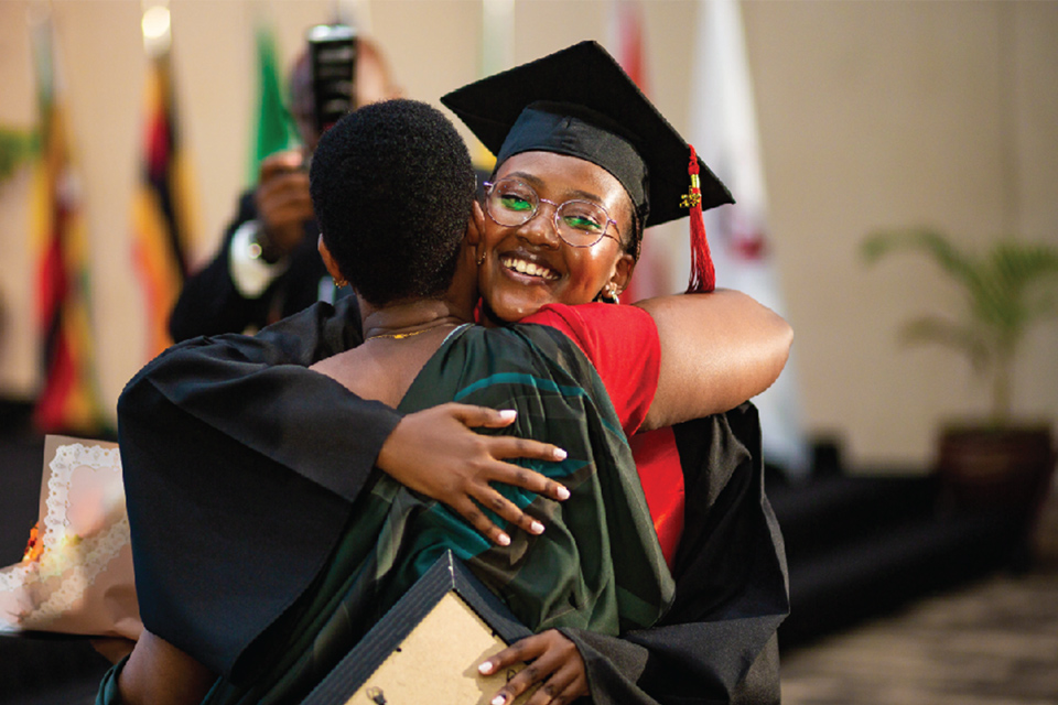 UGHE graduates hugging