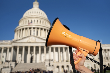 a bright orange megaphone labeled Partners In Health in front of the U.S. Capitol building