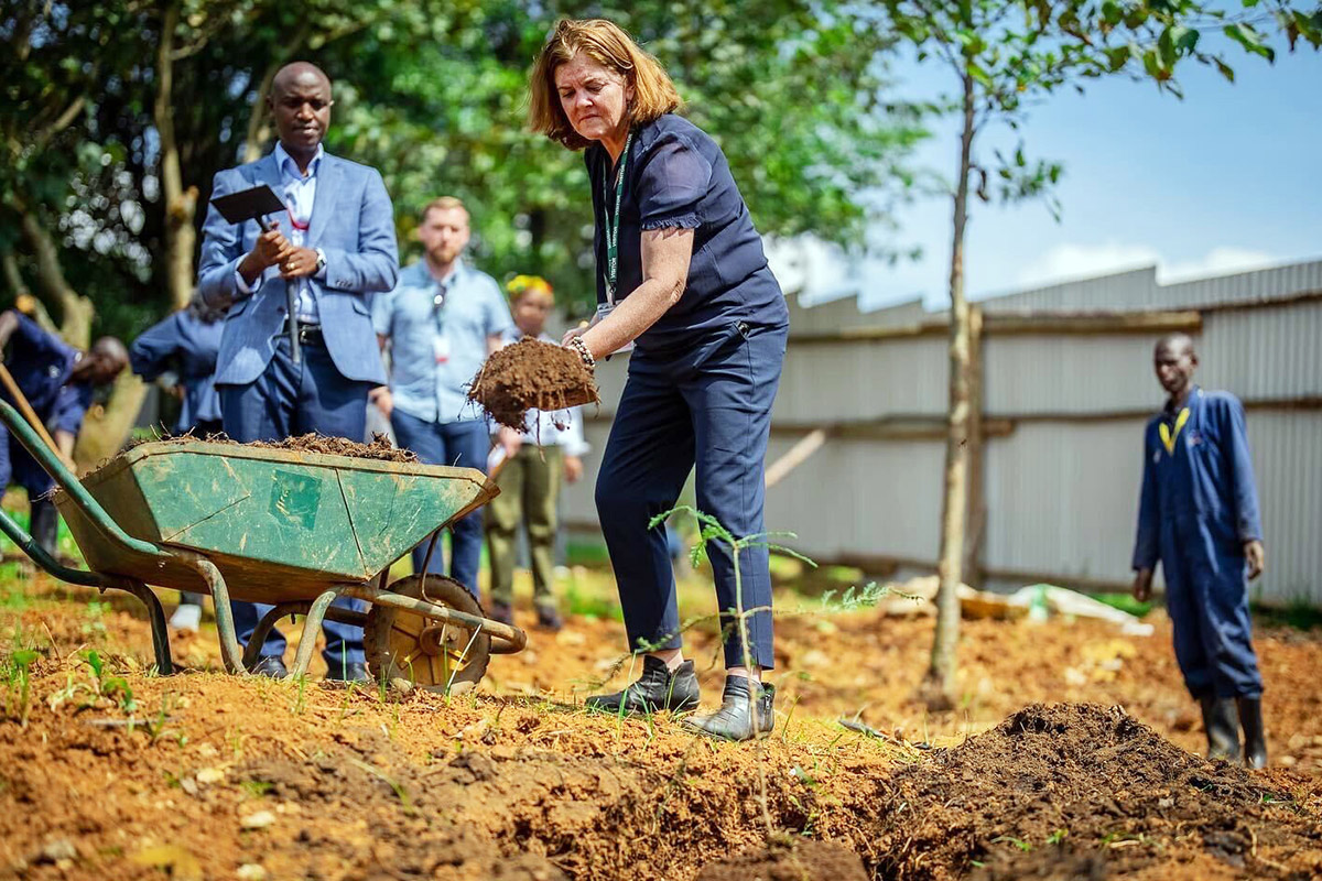 CEO Sheila Davis plants a tree in honor of Paul Farmer while visiting the University of Global Health Equity in Rwanda in June, 2022.
