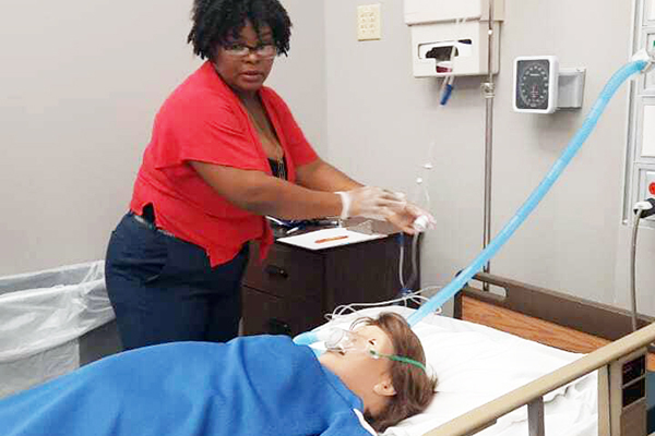 Nurse educator Claudinette Favard working on a mannequin in the simulation lab. 