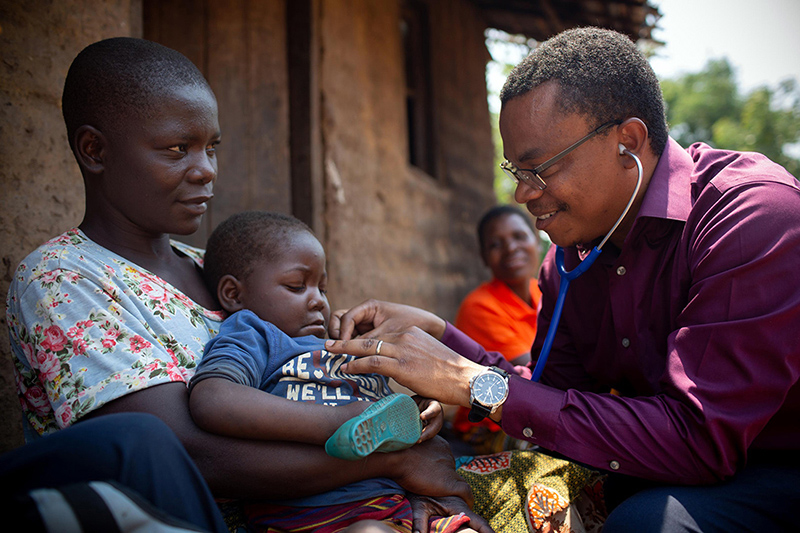  Dr. Dimitri Suffrin checks on HIV and malnutrition patient Agnes Makunda, 3, while she is held by her mother, Margaret. ....CHW Blandina George, TB & HIV program manager Dr. Dimitri Suffrin, CHW site supervisor Elizabeth Chikapa, and HIV officer Chisomo Kanyenda visit the home of Margaret Makunda, 28, and Agnes Makunda, 3. Both are HIV patients receiving ART and Agnes is enrolled in the malnutrition program. 