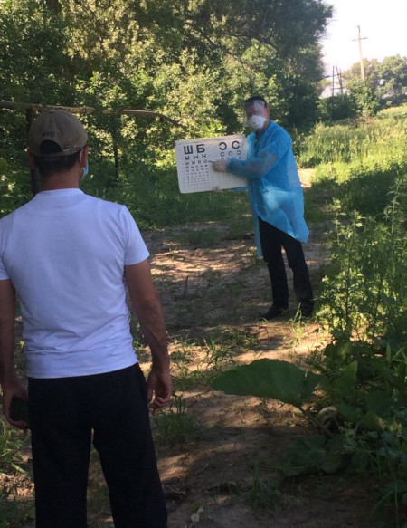 Dr. Amanjan Abubakirov gives a roadside vision test to a TB patient