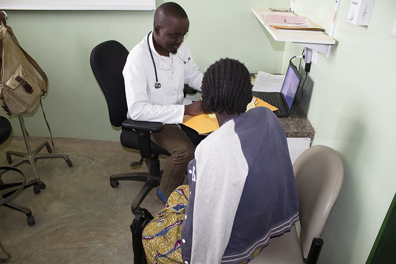 Clinician Bright Mailosi talks with a patient in Neno, Malawi 