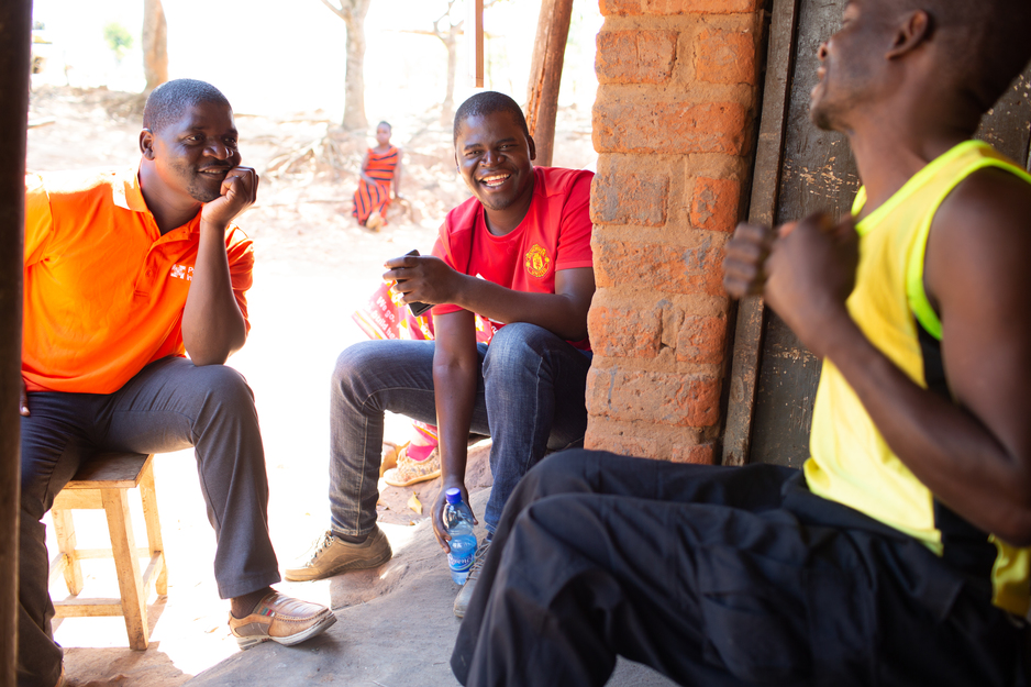 Benson Chabwera talks with a mental health patient's brother on a home visit