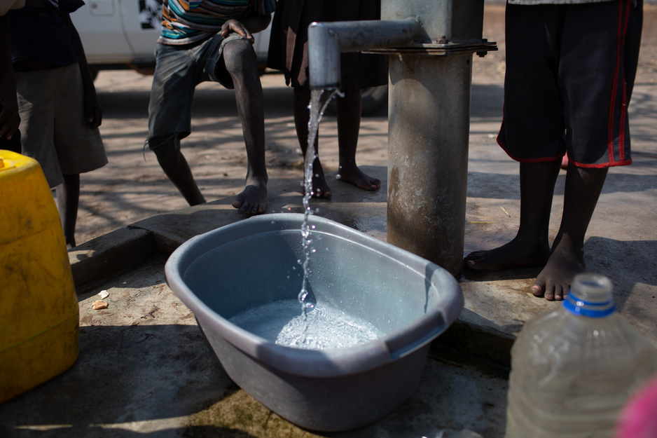 Children gather around a public water pump in rural Malawi