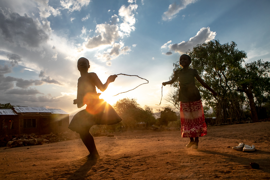 girls jump rope outside their home in Malawi