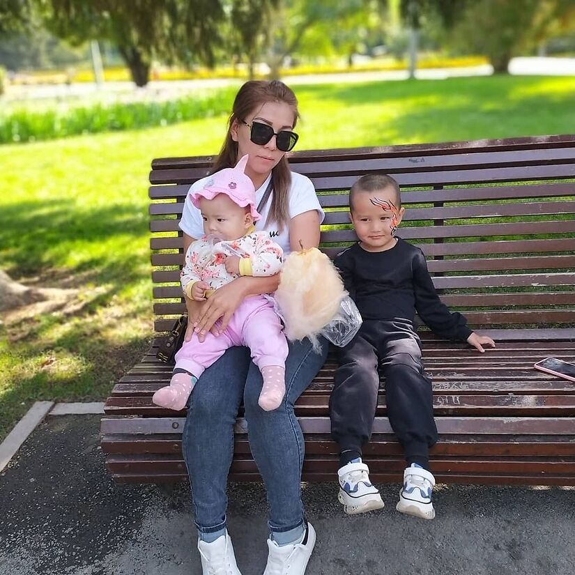 Shoraveva sitting on park bench with two kids