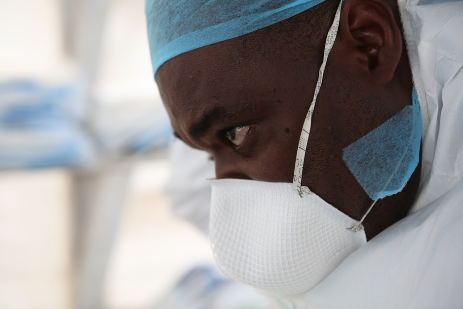 nurse puts on protective equipment before treating Ebola patients in Sierra Leone