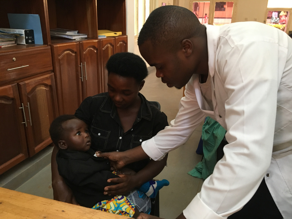 Pediatric nurse Silas Havugarurema examines 9-month-old Hazard Habwipano at Kirehe District Hospital