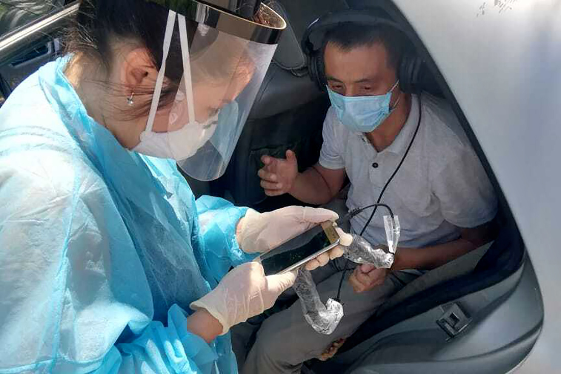 doctor gives audiology test to tuberculosis patient from car in Kazakhstan
