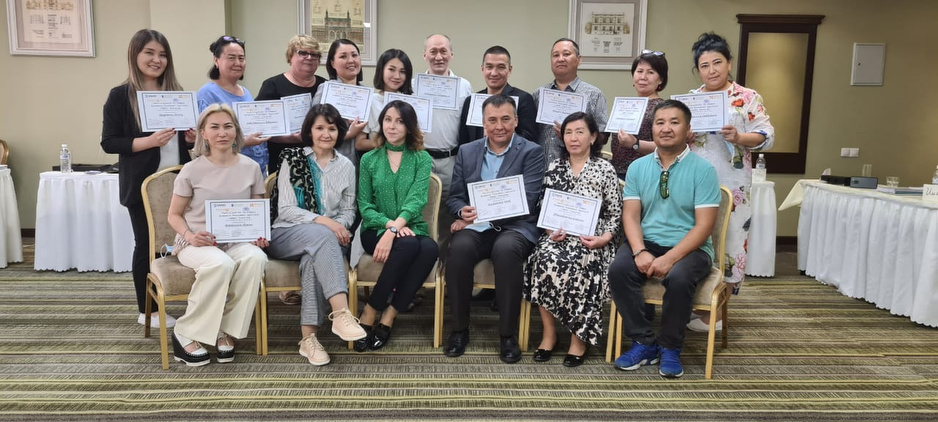 Participants in a mental health training stand with their certificates in May 2021.