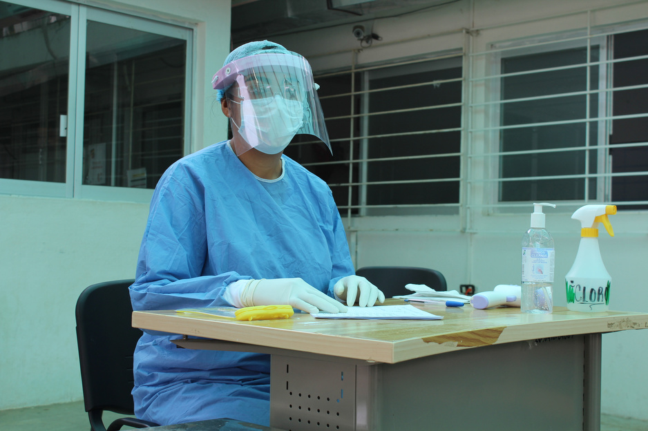 In this picture, a nurse wearing personal protective equipment sits in the triage area of the PIH-supported community hospital in Jaltenango. 