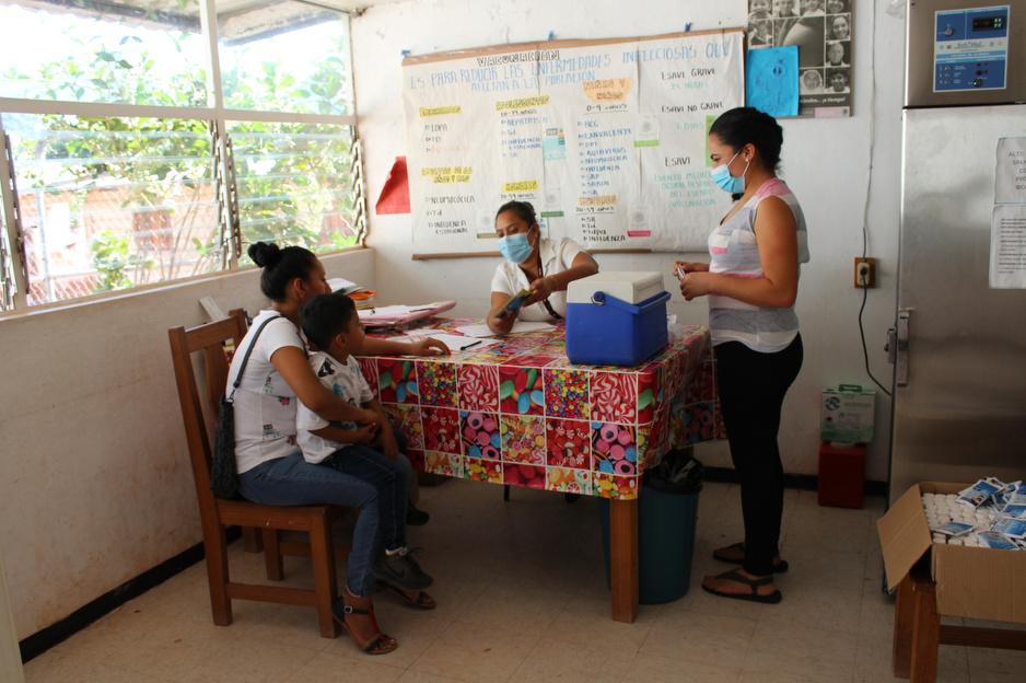 In this picture, Leini Escalante (right), a community health worker, supports  Erika Osorio (middle), a nurse, during an influenza vaccination campaign. 