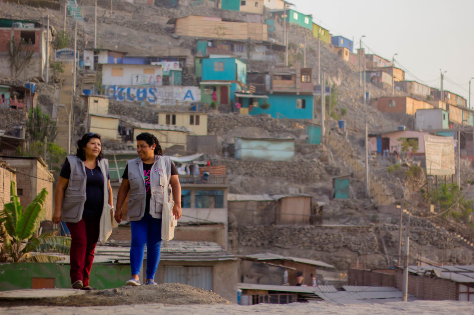 Community Health Workers Inela Espinoza (right) and Dina Gomez (left) walk through San Gabriel, Carabayllo, after conducting a training session for caretakers and mothers in May 2016.