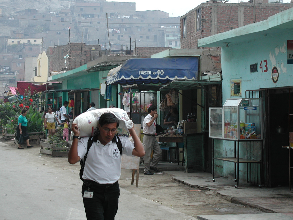 Hildo Miranda, a health promoter with Socios En Salud recruited by the late Father Jack Roussin, carries food supplements through the streets of Carabayllo in 2001.