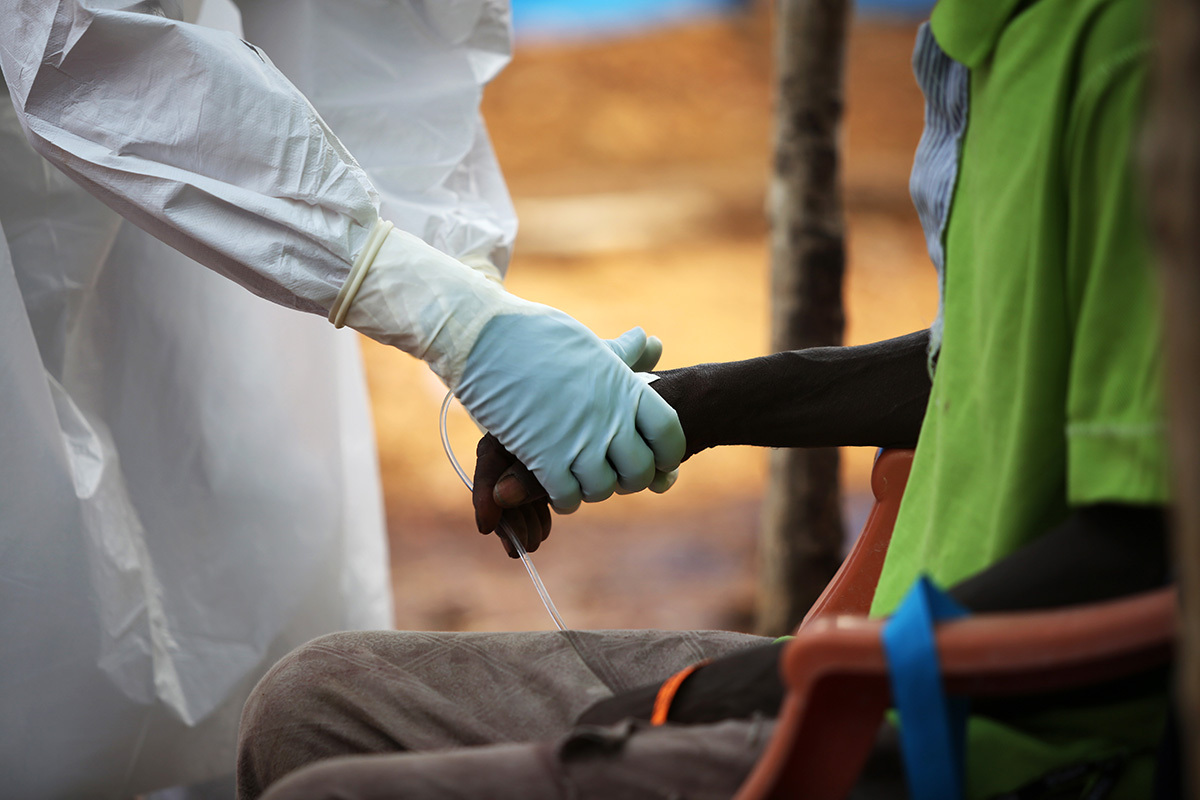 PIH clinicians and sprayers receive patients in the triage area of the Maforki Ebola Treatment Unit in 2015.