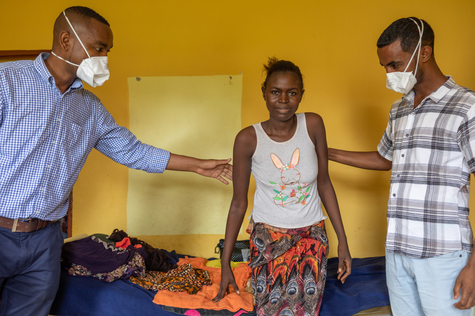 Saffiatu Sesay receives care at Lakka for spinal TB. Dr. Michael Mazzi (left) and Dr. Girum Tefera support her. Photo by John Ra / Partners In Health.