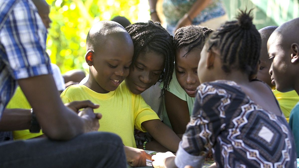 children read together outside at a children's home in Haiti
