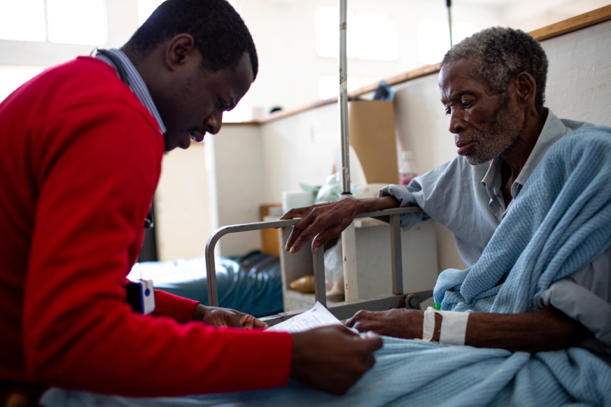 Dr. George Talama talks with a patient showing cancer symptoms at Neno District Hospital 