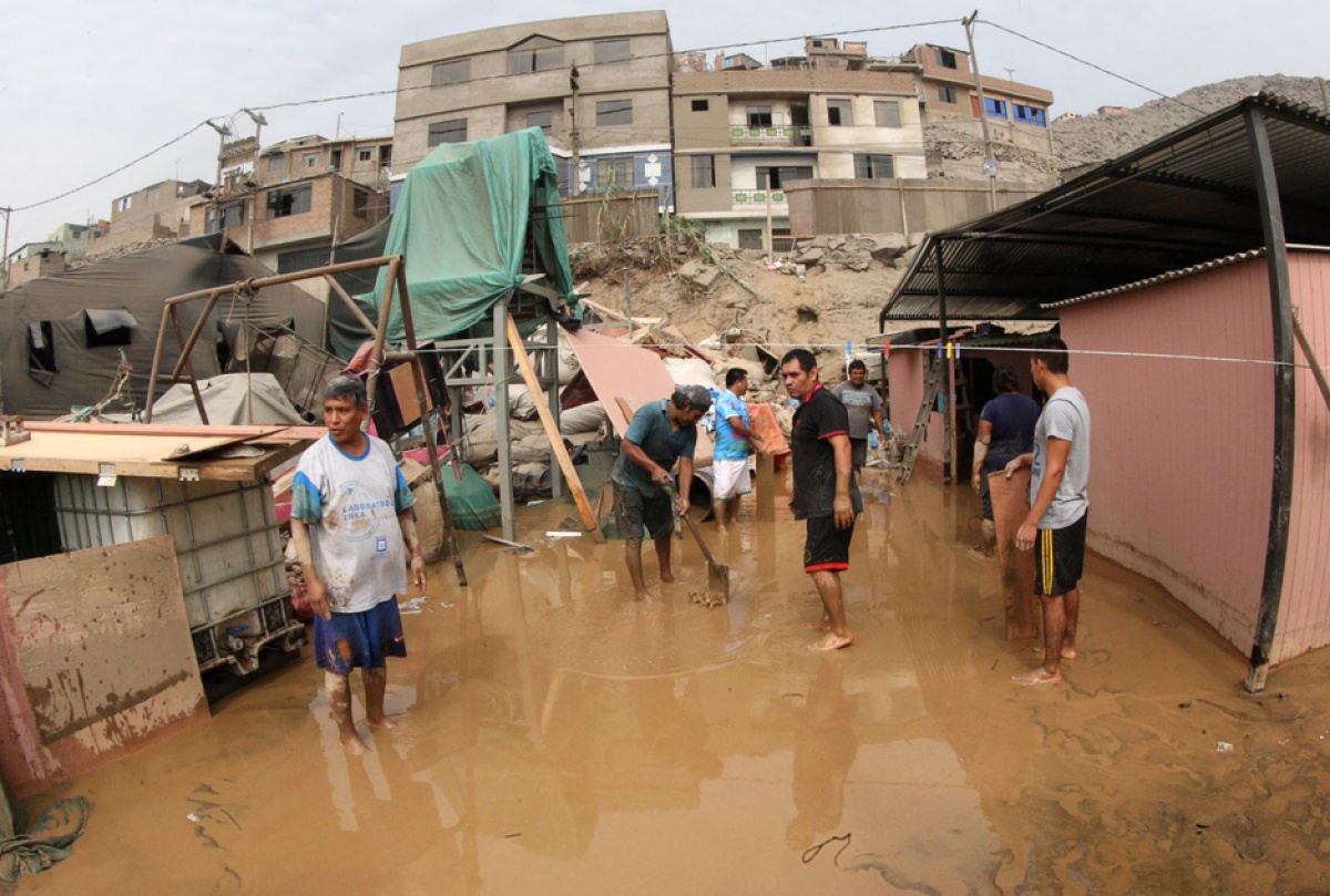 neighbors clear streets following massive floods in Lima, Peru