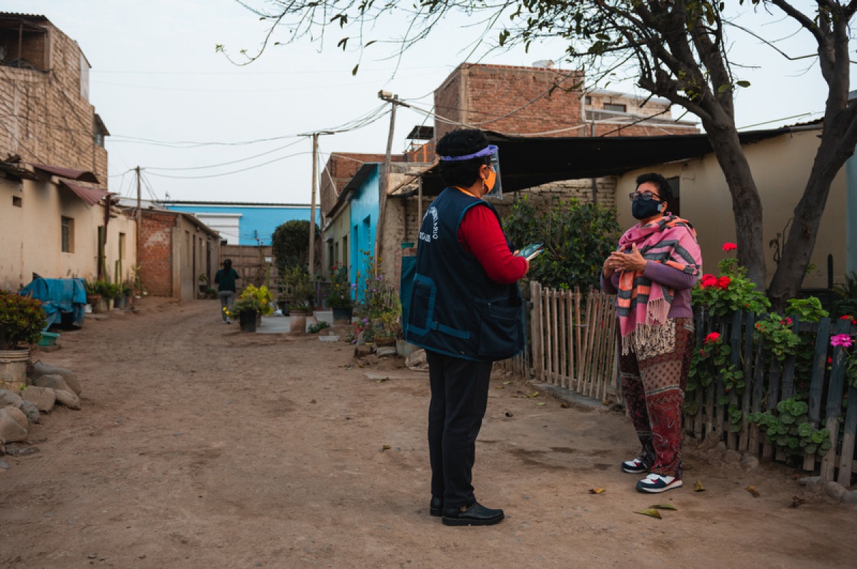 A staff member with Socios En Salud, as PIH is known in Peru, does a door-to-door mental health screening with a patient after a chatbot app connected them.