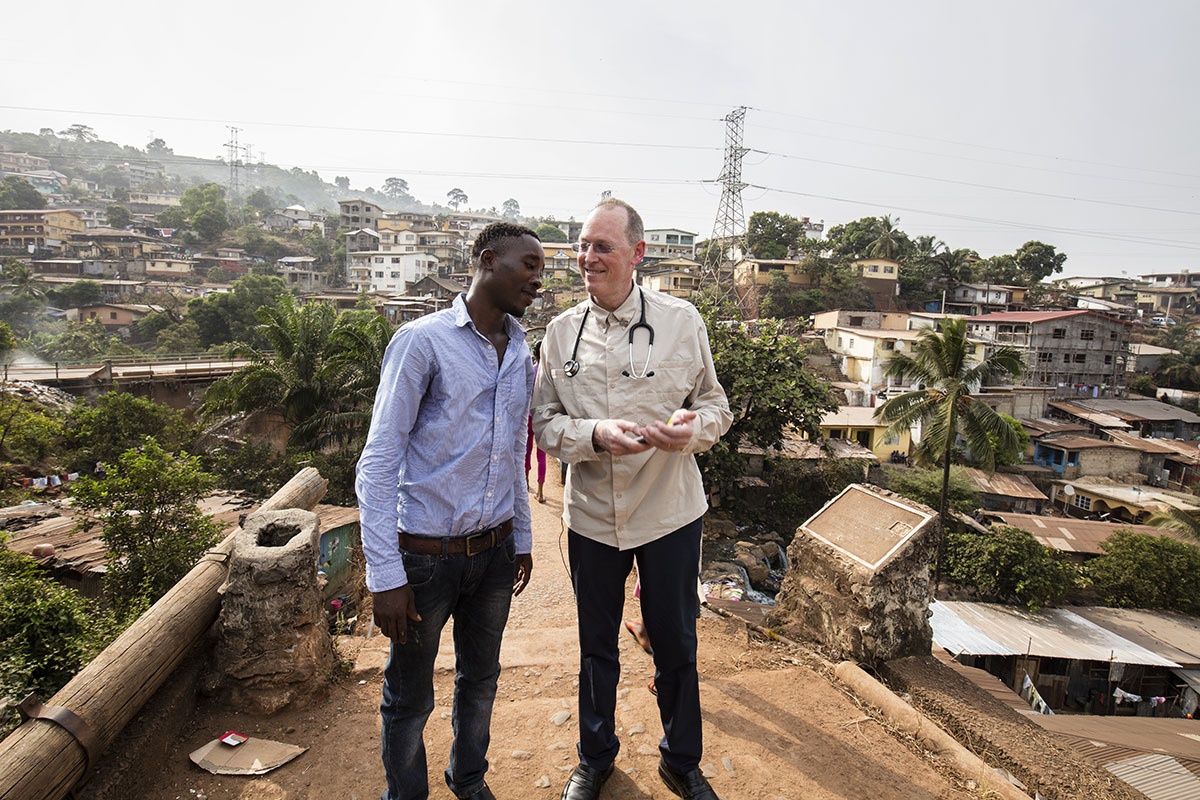Paul Farmer stands on the Tengeh Town Bridge with Ibrahim Kamara in Freetown, Sierra Leone in 2015.