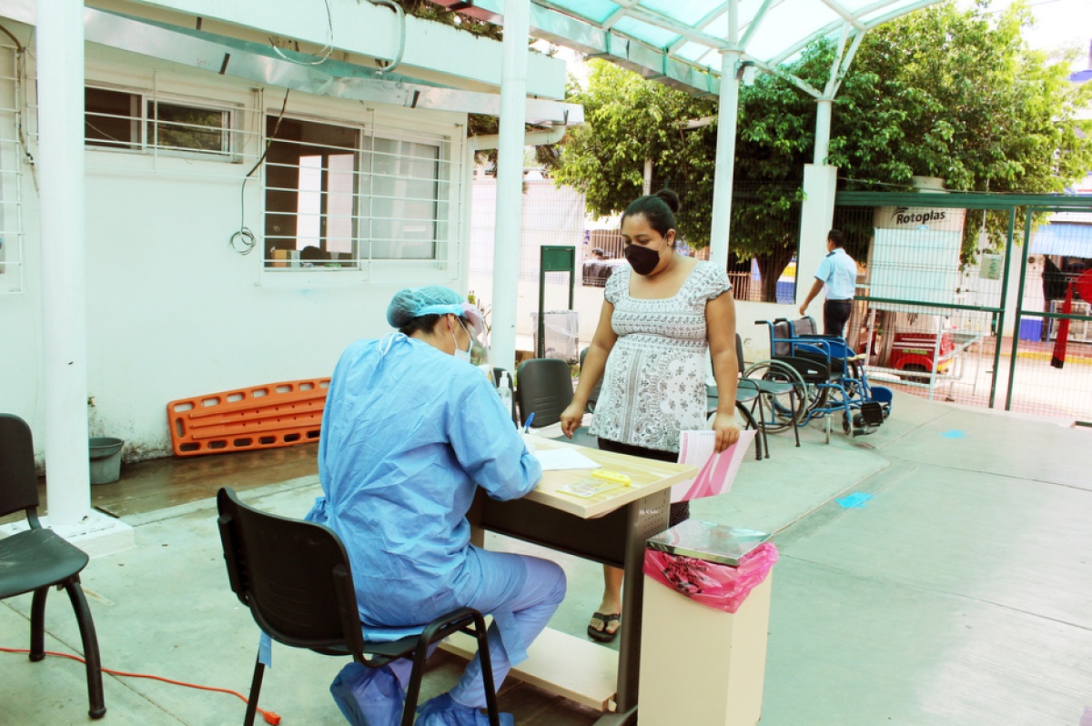 In Mexico, a nurse in PPE helps a patient in the triage area of the hospital.