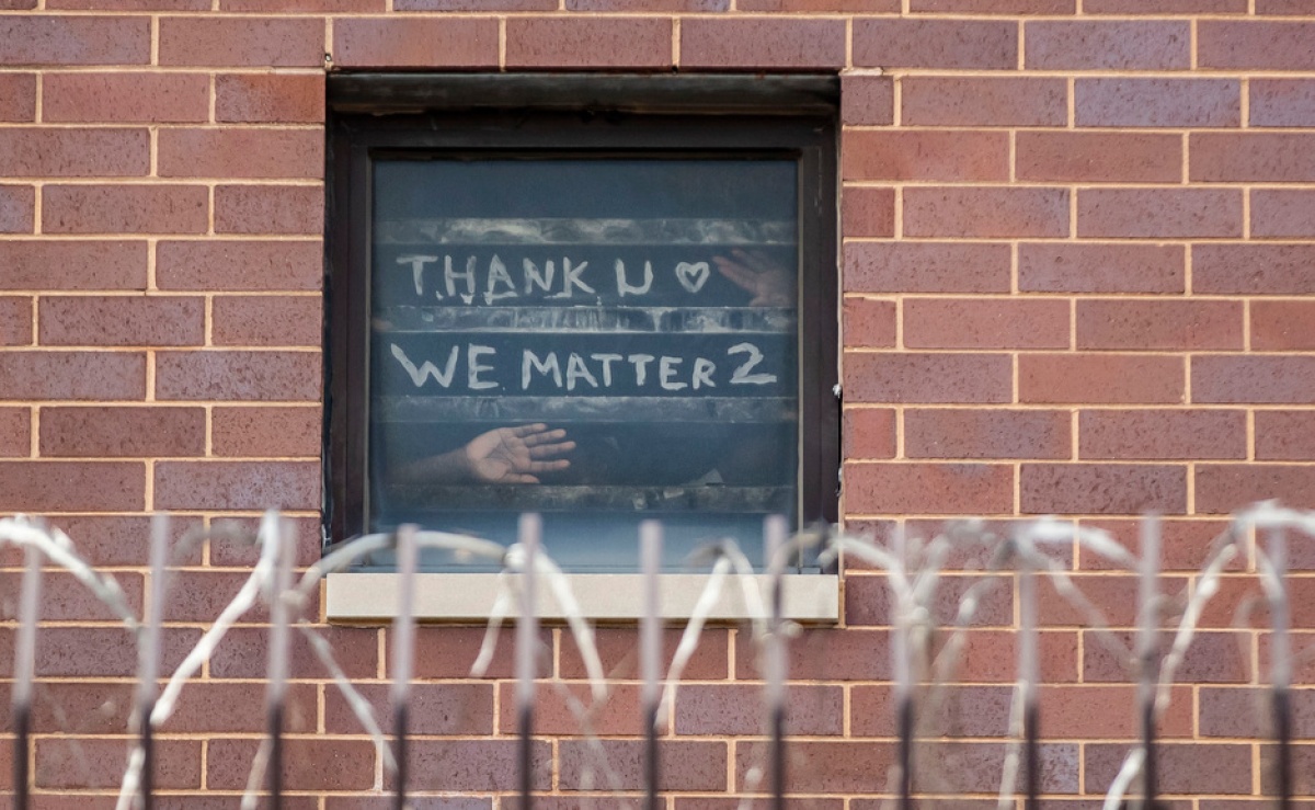 At Cook County Jail in Illinois, where COVID-19 has run rampant through prisons, incarcerated people hold a sign up to a window that says thank you, we matter too.