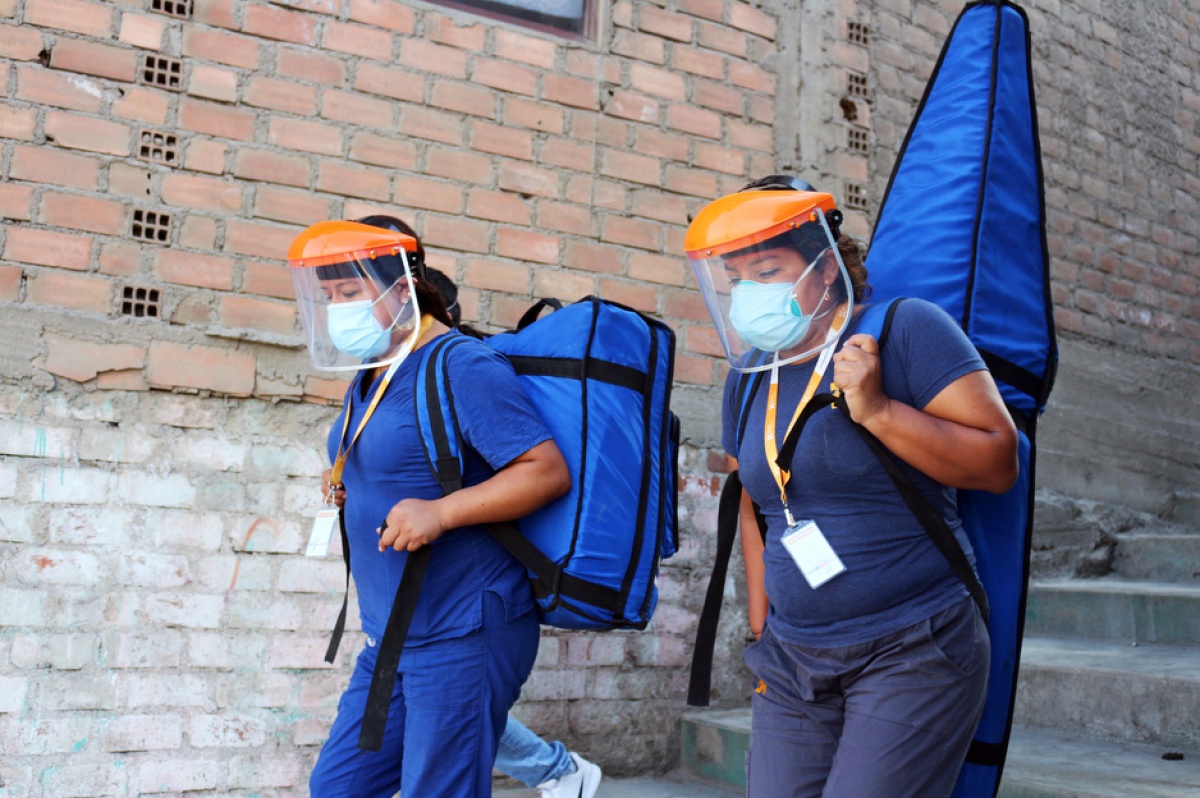 Health care workers from Socios En Salud, as PIH is known in Peru, carry the "Backpack TB" machine.