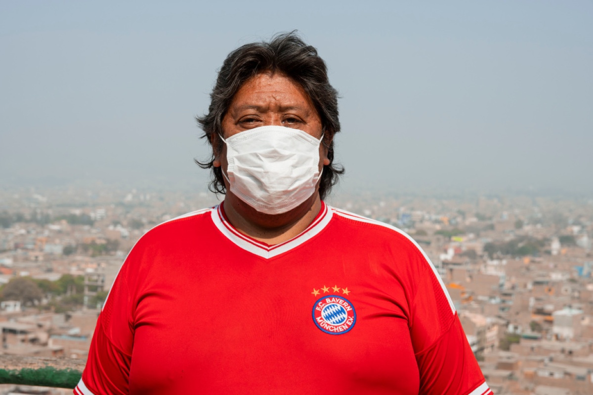 Félix Melgar stands near his home in Carabayllo, Peru, with the city in the background.